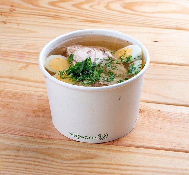 Chicken broth with quail egg Healthy food Takeaway food On a wooden background