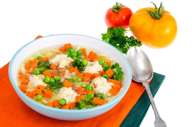 Chicken broth with vegetables, pasta and meatballs.