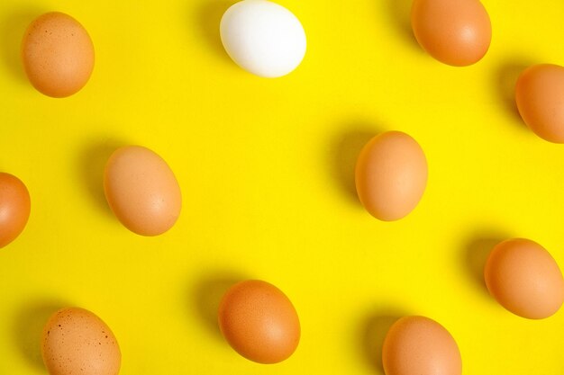 Chicken brown and white eggs on a yellow background.