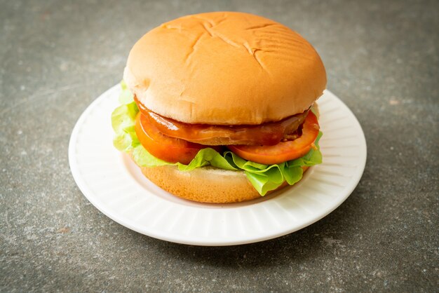 chicken burger with sauce on white plate