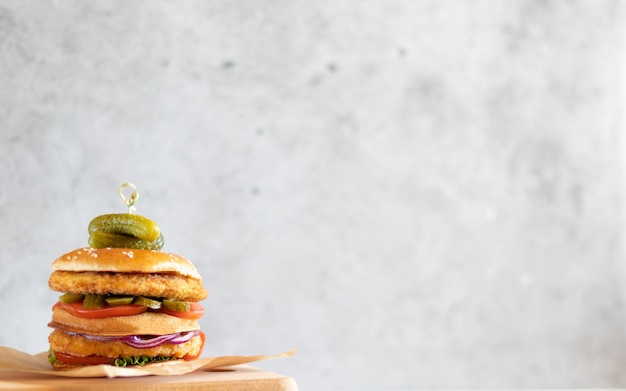 Chicken burger on wooden board on light background with copy space on the right