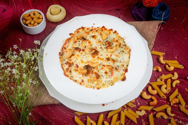 Chicken cheese Cashew nuts pasta in a plate side view on wooden background