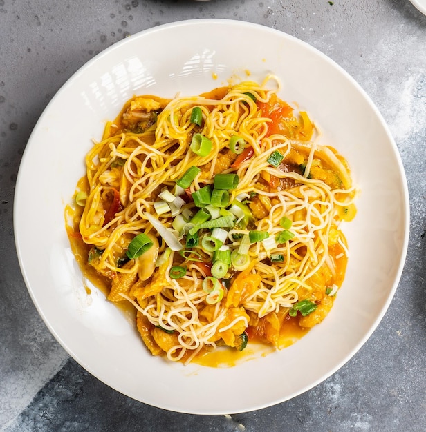 Chicken Chow mein geserveerd in een schotel geïsoleerd op een donkere achtergrond bovenaanzicht