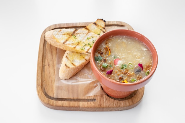 Chicken Corn Soup met lookbrood geserveerd in een kom geïsoleerd op een grijze achtergrond bovenaanzicht