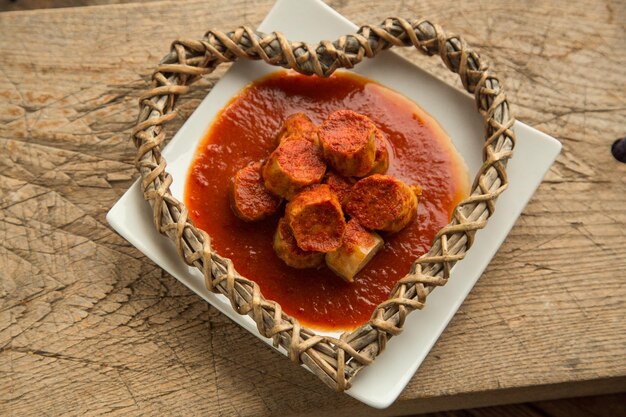 Salsicce di pollo al curry servite alla piastra con salsa speciale bavaresi alla griglia con condimenti