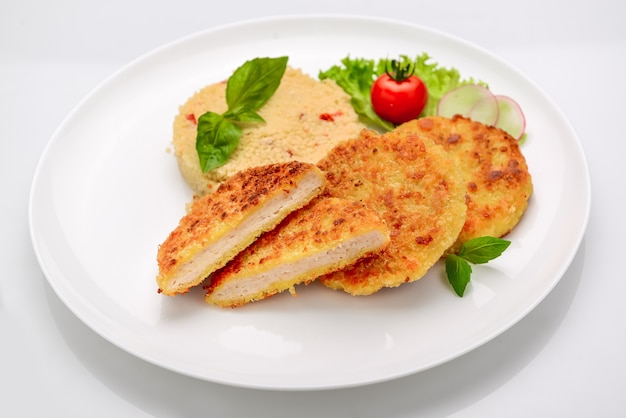 Chicken cutlet in batter with bulgur on a white background