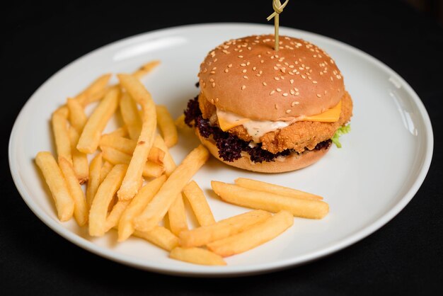 白いプレートにチキンカトレットバーガーとフライドポテト