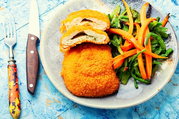 Foto cotoletta di pollo con contorno di asparagi e carote. cibo tradizionale ucraino