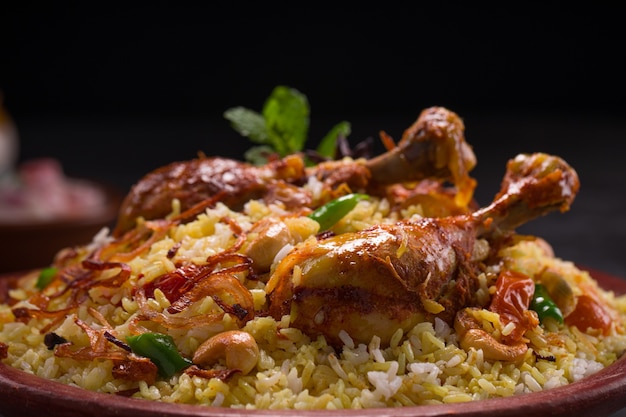 Pollo dhum biriyani con riso jeera e spezie disposte in vasellame di terracotta