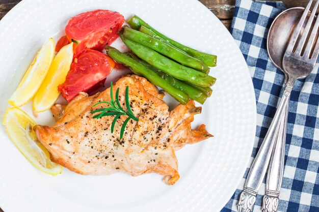 Chicken dish with vegetables and french fries