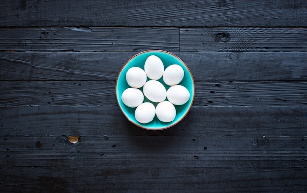 Chicken egg on a dark wooden background, free space for text.