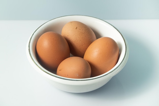 Foto uovo di gallina su sfondo bianco e ciotola