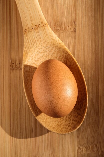 Photo chicken egg on a wooden spoon