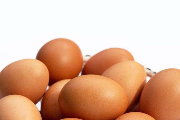 Chicken eggs in bamboo basket on white.