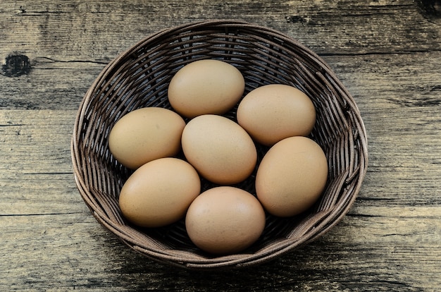 Chicken eggs in brown basket.