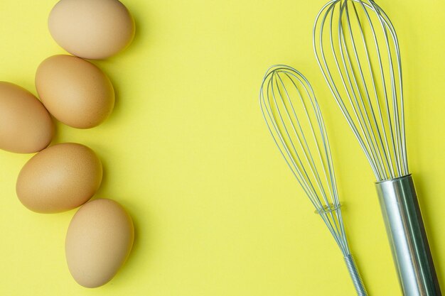 Chicken eggs brown eggs broken egg in carton box on yellow
background