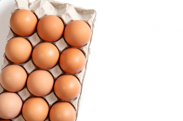 Chicken eggs in a cardboard box on white . Organic Food.Top view