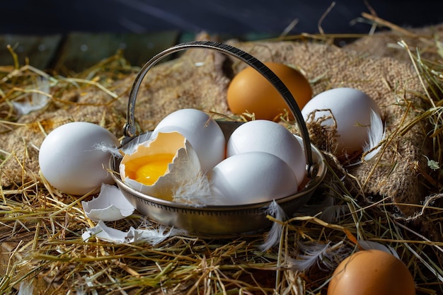 Photo chicken eggs on dry grass on an old background