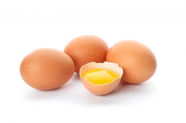 Chicken eggs and half broken egg with yolk