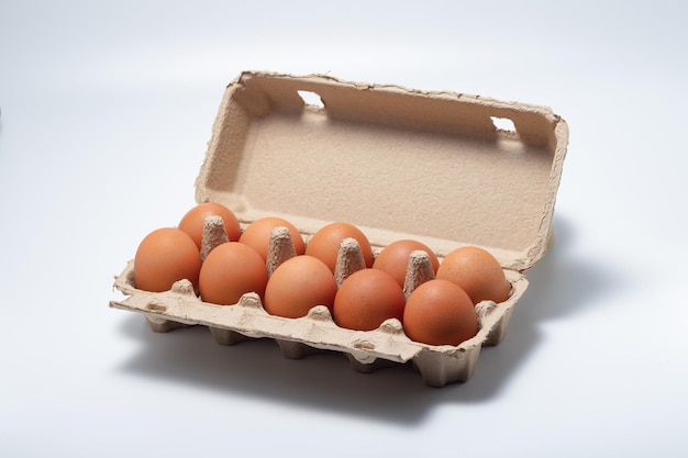 Фото Куриные яйца в открытой коробке для яиц, изолированные на белом фоне свежие куриные яйца яйца в коробке
