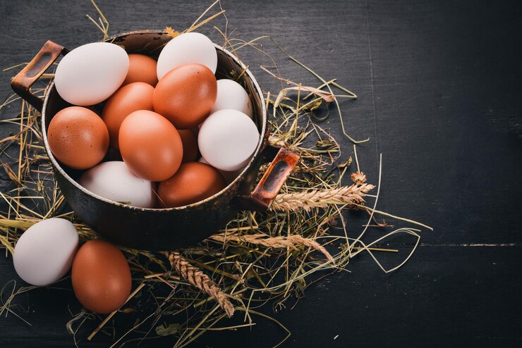 Chicken eggs in a metal saucepan On a wooden background Top view Copy space