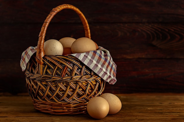 Chicken eggs in a nest made of hay and wicker basket