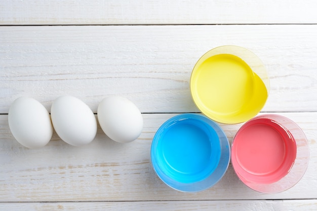 Куриные яйца и краски на столе