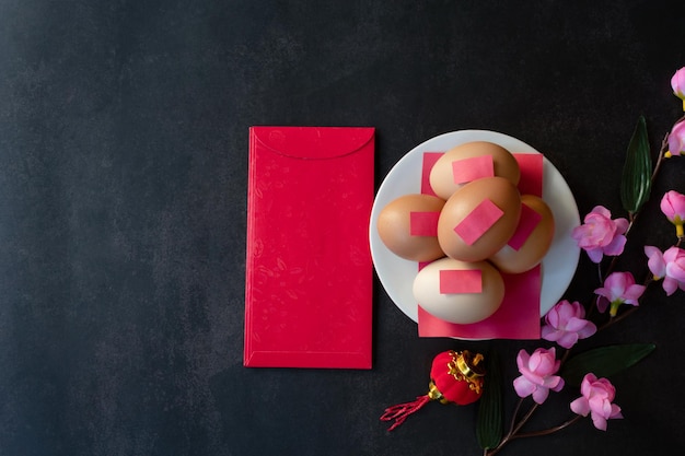 Chicken eggs and red envelopes on a plaster background for Asian New Years Eve festivals