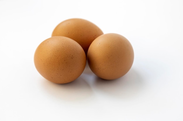 Chicken eggs on a white background close up three raw eggs