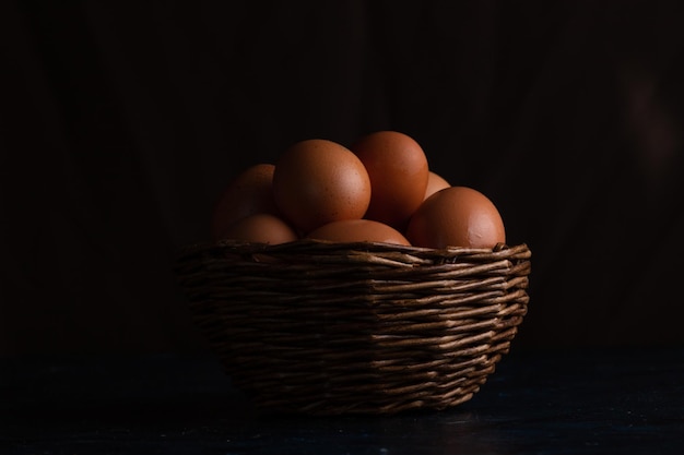 Chicken eggs in a wicker basket and on a towel