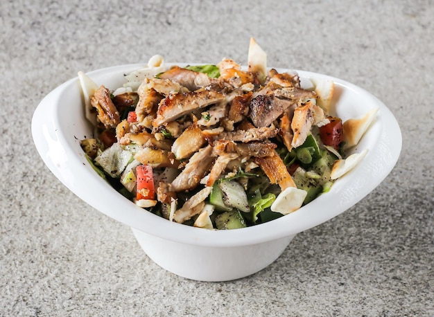 Chicken fattoush bil dajaj with cucumber and tomato served in dish isolated on background top view of Arabic fast food