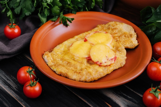Chicken fillet baked in the oven with cheese and tomatoes
