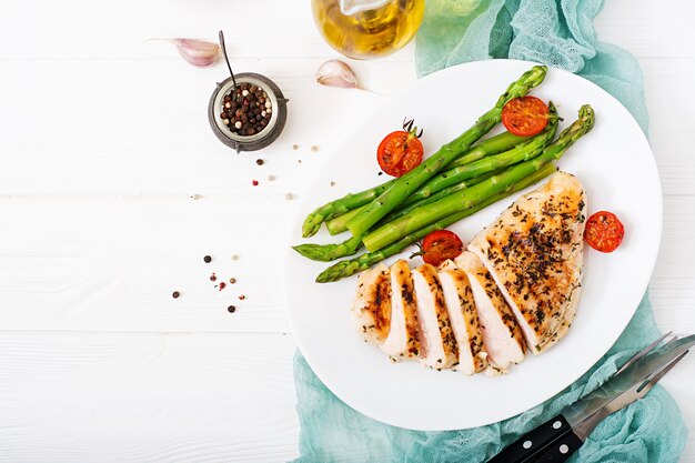 Chicken fillet cooked on a grill and garnish of asparagus.