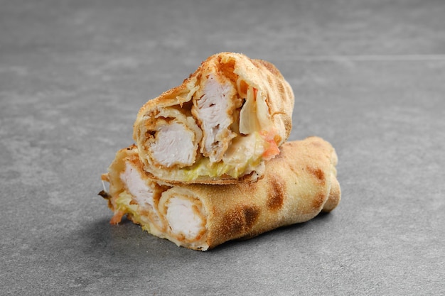 Chicken fillet rolled and baked in dough with cabbage tomato and cheese cut on half