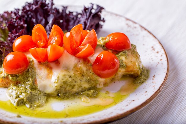 Chicken fillet with cherry tomatoes and pesto sauce.