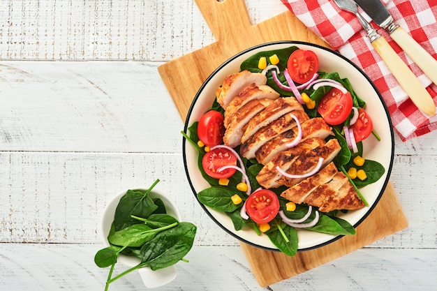 Chicken fillet with salad spinach, cherry tomatoes, cornflower and onion