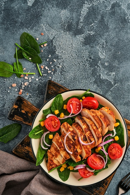 Chicken fillet with salad spinach, cherry tomatoes, cornflower and onion