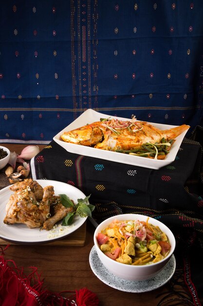 Photo chicken and fish with salad in plate on table