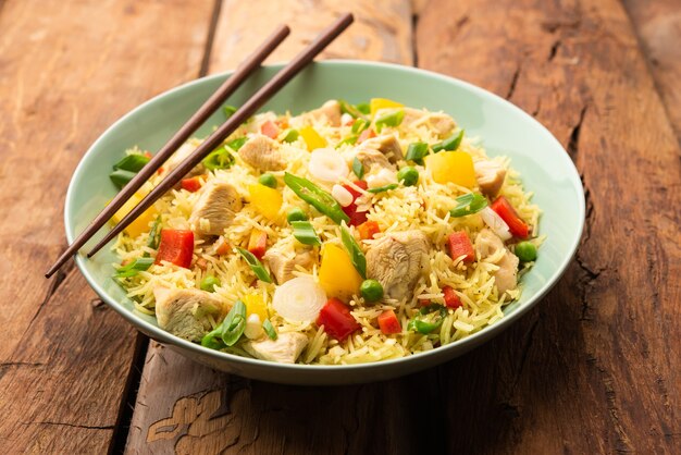 Photo chicken fried rice is a popular indian chinese or indo-chinese street food served in a plate with chopsticks