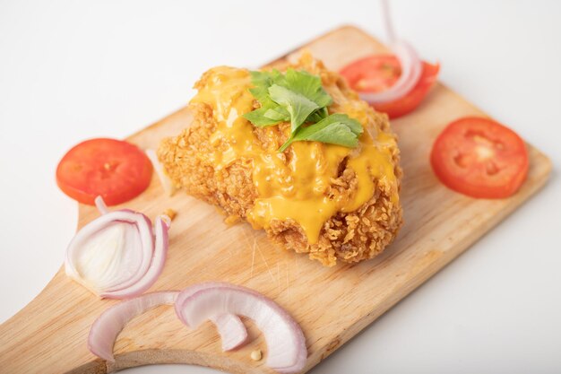 Foto pollo fritto con il formaggio sul tavolino da taglio
