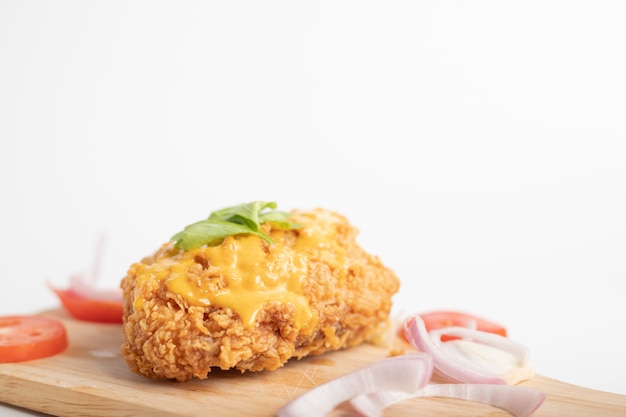 Chicken fried topped cheese on the wooden board and white background