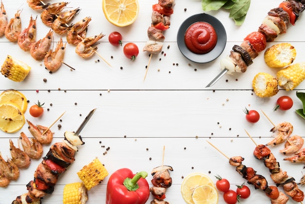 Foto spiedini di pollo alla griglia con cornice di verdure