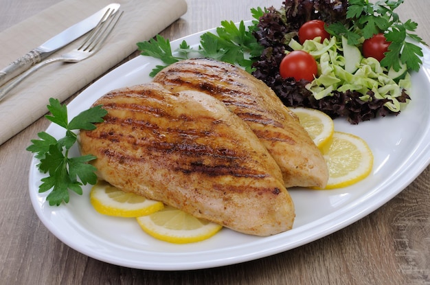 Pollo alla griglia con insalata su un piatto