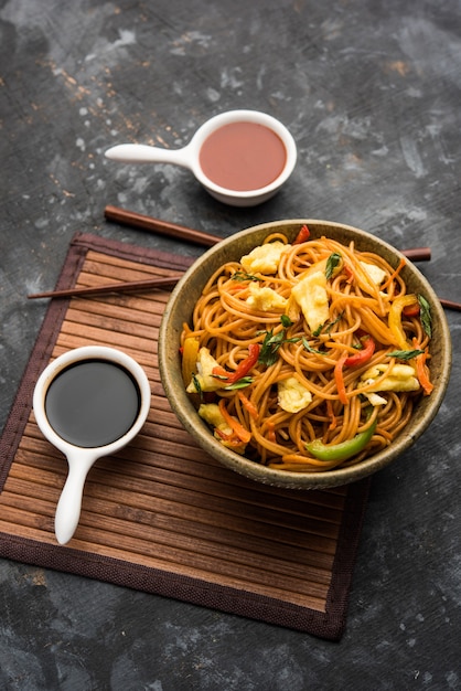 Chicken Hakka or Schezwan noodles served in a bowl with chopsticks. selective focus