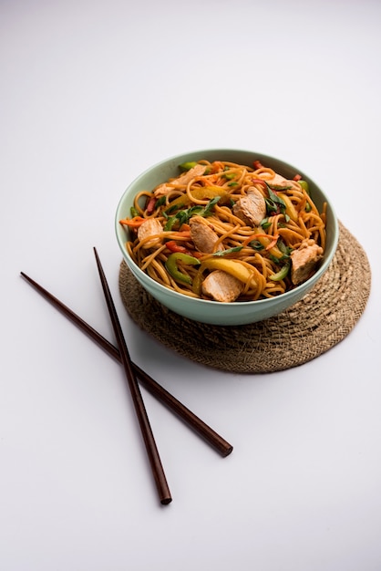 Chicken Hakka or Schezwan noodles served in a bowl with chopsticks