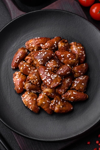 Photo chicken hearts fried in soy sauce with salt and spices in a plate