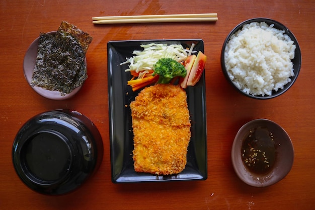 chicken katsu don is japanese food served with soy sauce on table