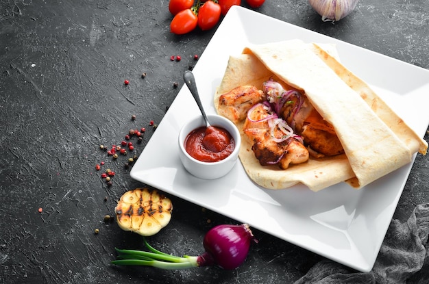 Chicken kebab with onions in pita bread meat skewers top\
view