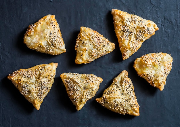 Chicken leek puff pastry samsa on a dark background top view