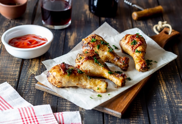 Chicken legs on a wooden table. Barbecue. Grill. American cuisine. Recipe. Rustic.